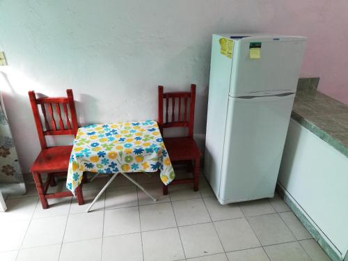 a table and two chairs and a refrigerator in a kitchen at Habitaciones amuebladas. Poliforum/Centro in León