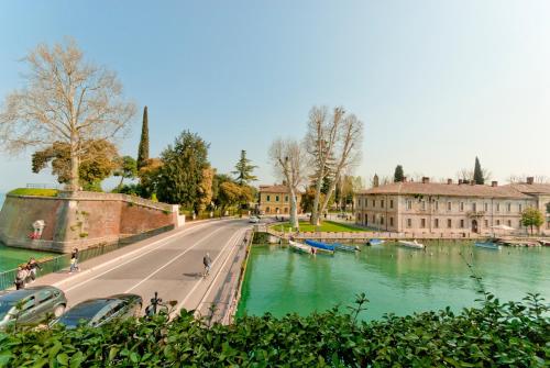 a road next to a river with cars parked on it at Hotel Bell'arrivo by Dori in Peschiera del Garda