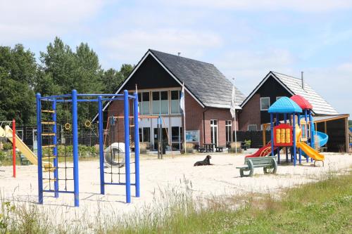 een speeltuin voor een gebouw met speeltoestellen bij Vakantiepark De Kremmer in Gasselte