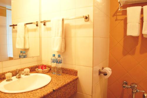 a bathroom with a sink and a mirror and towels at Hotel Gloria La Paz in La Paz