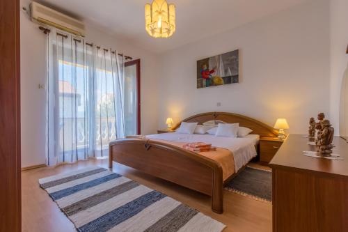 a bedroom with a bed and a large window at Apartman Laura in Selce