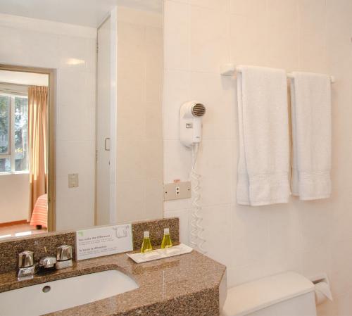 a bathroom with a toilet and a sink and a mirror at Girasoles Hotel in Lima