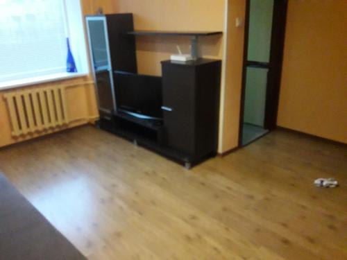 2 istabu dzīvoklis في Aizkraukle: غرفة معيشة مع تلفزيون وأرضية خشبية