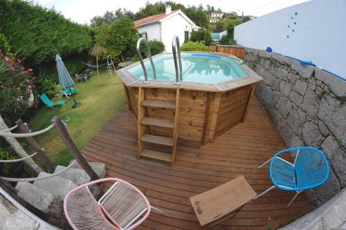a hot tub on a wooden deck with two chairs at Moinho do Prado in Vila Nova de Cerveira
