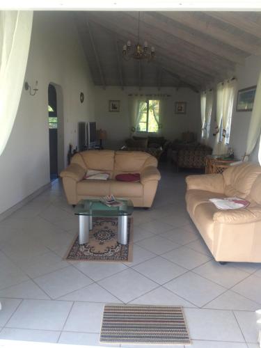 a living room with two couches and a table at Spacious White House Villa 1 minute to sandy beaches in Saint James
