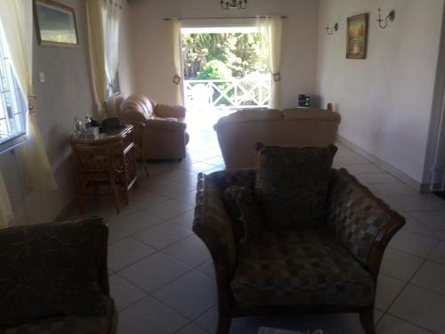 a living room with a couch and a chair at Spacious White House Villa 1 minute to sandy beaches in Saint James