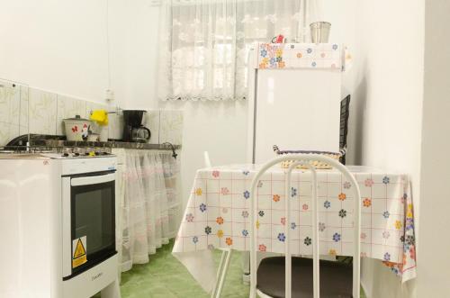 uma cozinha com uma mesa e um frigorífico branco em Chalé saí azul em Penedo