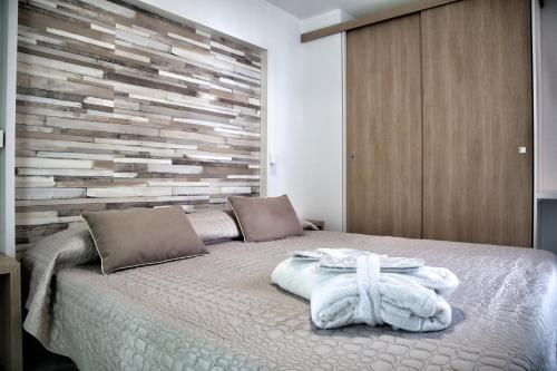 a bedroom with a bed with a wooden wall at Villaggio La Pescaccia in San Clemente