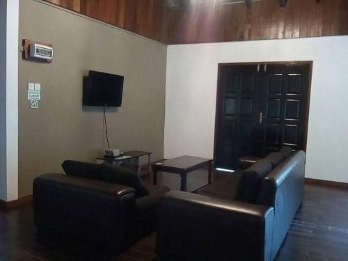 a living room with two couches and a tv at J Residence in Kundasang
