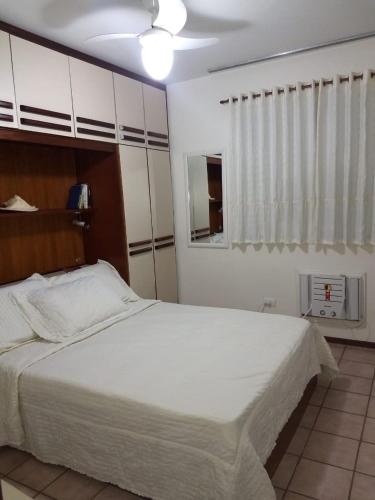 a bedroom with a large white bed and a window at Apartamento em Caioba com wi-fi in Matinhos