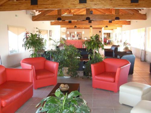 a lobby with red chairs and a piano at Club Valle Termal Resort in Federación