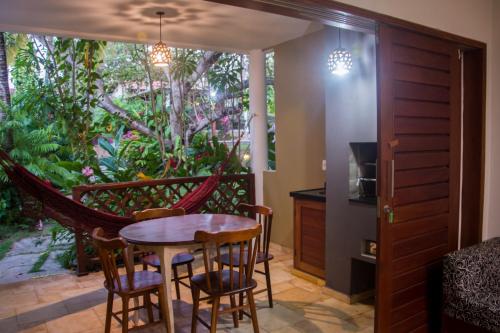 a room with a hammock and a table and chairs at Aldeia das flores in Pipa