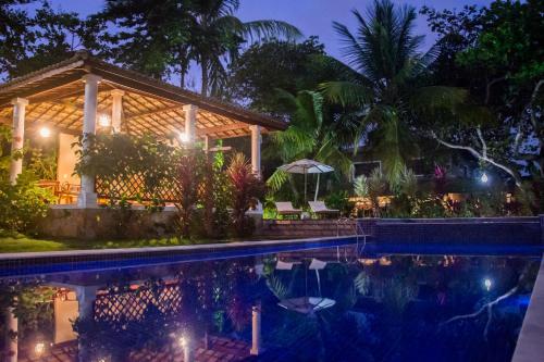 a villa with a swimming pool at night at Aldeia das flores in Pipa