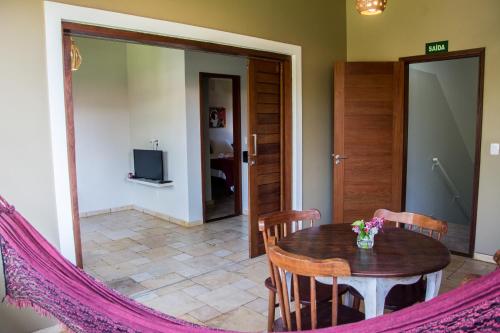 a dining room with a wooden table and chairs at Aldeia das flores in Pipa