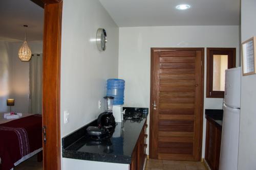 a kitchen with a counter with a coffee maker on it at Aldeia das flores in Pipa