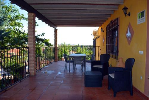 a patio with a table and chairs and a fence at El Retiro de Cervantes in Ossa de Montiel