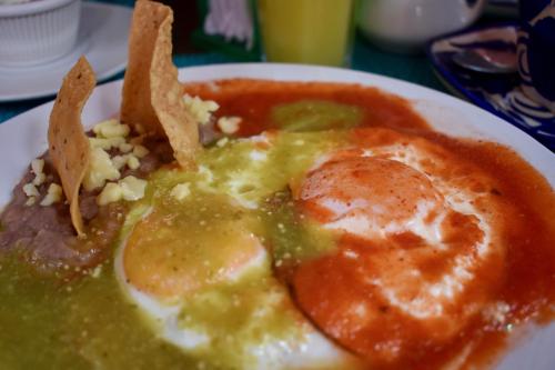 a plate of food with eggs and vegetables on a table at Hotel Ana Catalina and Suites in San Miguel de Allende