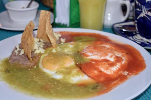 a plate of food with eggs and chips on a table at Hotel Ana Catalina and Suites in San Miguel de Allende