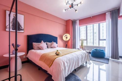 una camera da letto con un grande letto e pareti rosa di Zhengzhou Jinshui·Provincial Government· Locals Apartment 00161830 a Zhengzhou