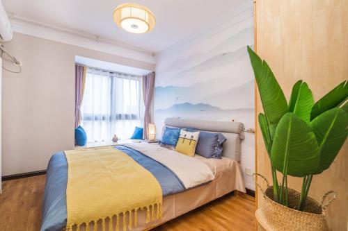 1 dormitorio con 1 cama y una maceta en Zhengzhou Zhongyuan·Zhongyuan Wanda· Locals Apartment 00159010, en Zhengzhou