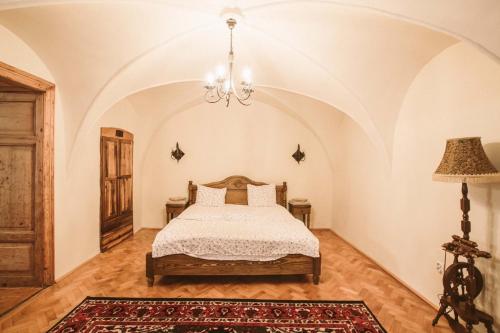 a bedroom with a bed and a chandelier at Casa Schobeln in Braşov