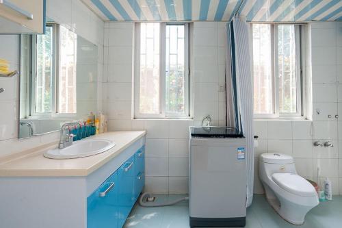 a bathroom with a sink and a toilet and windows at Zhengzhou Zhongyuan·Zhongyuan Wanda· Locals Apartment 00122680 in Zhengzhou