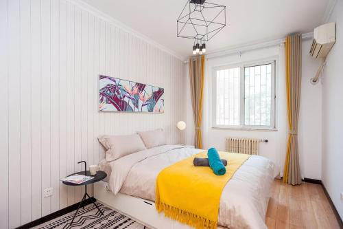 a bedroom with a bed with a yellow blanket at Zhengzhou Zhongyuan·Zhongyuan Wanda· Locals Apartment 00122680 in Zhengzhou