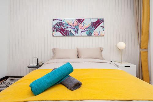 a bed with a blue pillow on a yellow blanket at Zhengzhou Zhongyuan·Zhongyuan Wanda· Locals Apartment 00122680 in Zhengzhou