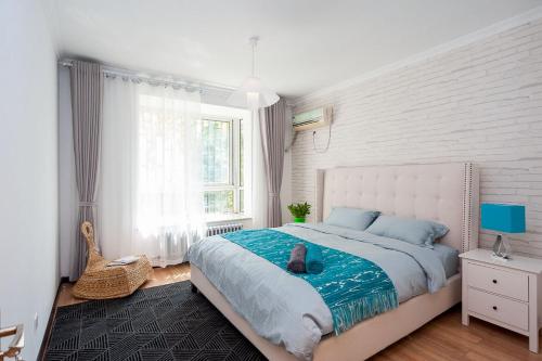 a bedroom with a large bed with a blue blanket at Zhengzhou Zhongyuan·Zhongyuan Wanda· Locals Apartment 00122680 in Zhengzhou