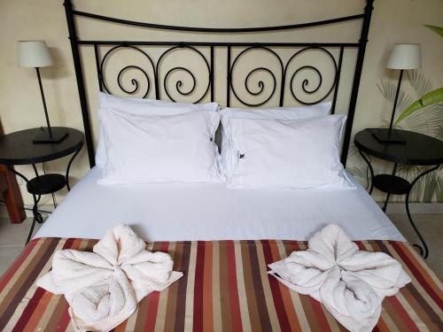 a bed with white pillows and towels on it at The Balboa Inn in Panama City