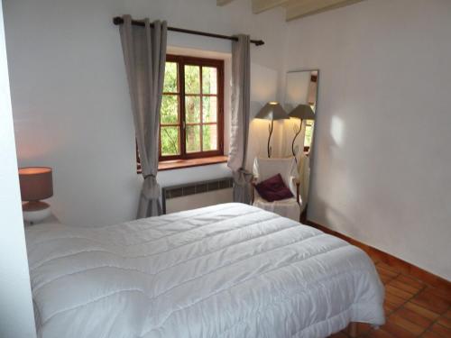 1 dormitorio con cama blanca y ventana en GITE "LES GILLES" ET SES ANIMAUX CALME-BON AIR - 5 personnes en Pinet