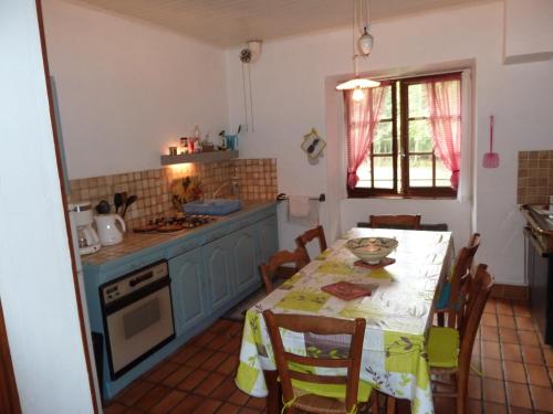 uma cozinha com uma mesa e um fogão forno superior em GITE "LES GILLES" ET SES ANIMAUX CALME-BON AIR - 5 personnes em Pinet