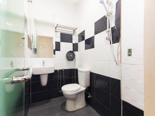 a bathroom with a toilet and a sink at Hotel Rosmerah in Ayer Keroh