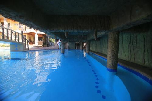 a swimming pool with blue water under a bridge at GingGing Hotel And Resort in Oslob