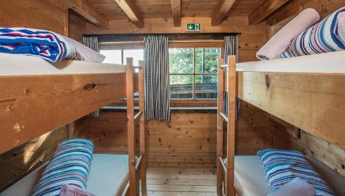 a room with three bunk beds in a log cabin at Hocheckhuette On Top of the Kitzbuehel Hahnenkamm Mountain in Kitzbühel