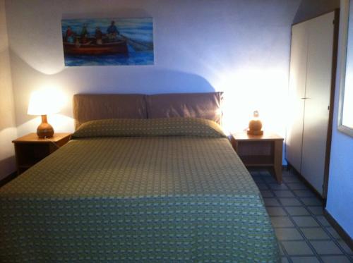 ein Schlafzimmer mit einem Bett und zwei Tischen mit Lampen in der Unterkunft La Fattoria in Sciacca