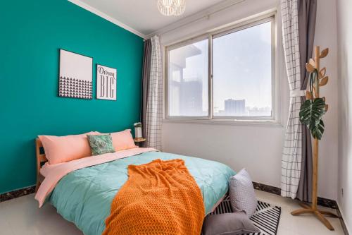 een slaapkamer met blauwe muren en een bed met een oranje deken bij Zhengzhou Shangjie·Near Wuyun Mountain· Locals Apartment 00144970 in Beixiawo