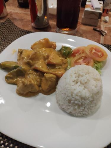a plate of food with chicken and rice on a table at Blue Ribbon Dive Resort in Mabini