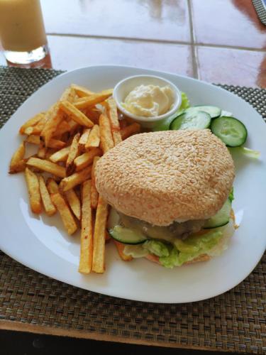 a white plate with a sandwich and french fries at Blue Ribbon Dive Resort in Mabini