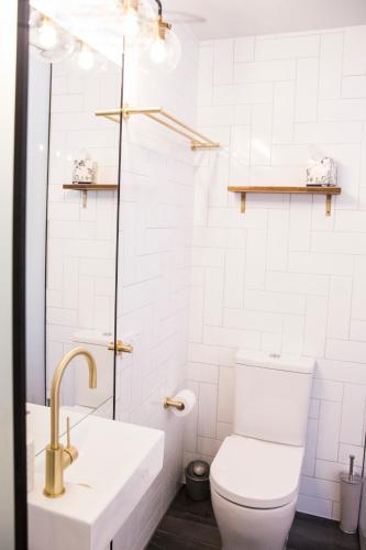 a white bathroom with a toilet and a sink at Bayhaven Lodge in Byron Bay