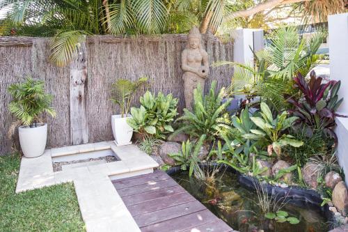 a garden with a wooden path and plants and a fence at Bayhaven Lodge in Byron Bay