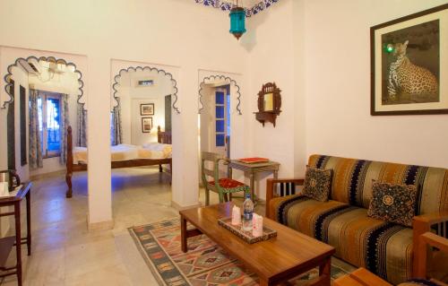 
a living room filled with furniture and a large window at Lake Pichola Hotel in Udaipur
