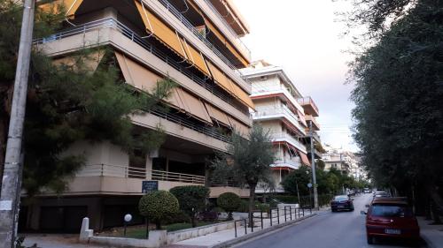 un bâtiment avec des voitures garées devant lui dans une rue dans l'établissement City Break Nearby Metro And Bus Express Airport, à Athènes