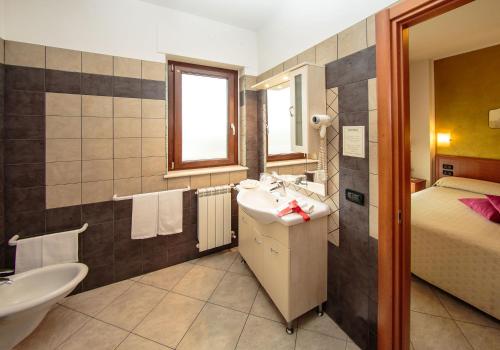 bagno con lavandino e letto di Hotel Residence Eden a Mozzagrogna
