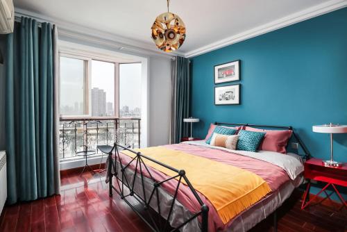 una camera con un letto con una parete blu di NanJing GuLou·Lion Bridge· Locals Apartment 00152470 a Nanjing