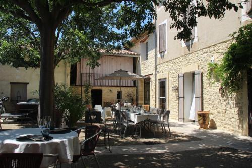 Carombにあるle clos du Patreの屋外レストラン(テーブル、椅子、木付)