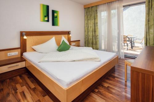 Schlafzimmer mit einem Bett mit weißer Bettwäsche und einem Fenster in der Unterkunft Apart Sunshine in Ladis
