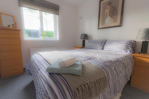 a bedroom with a bed with two towels on it at Riverside Cottage in Carrickfergus