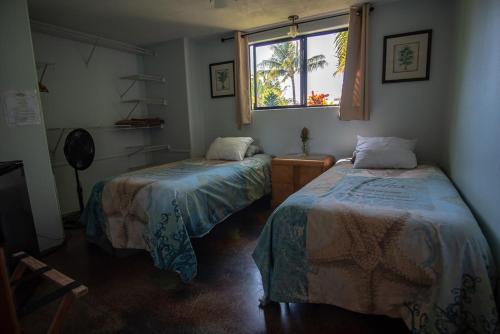 a room with two beds and a window at God's Peace of Maui in Makawao