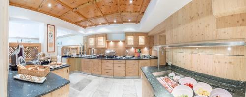 een grote keuken met houten kasten en werkbladen bij Landhaus Sepp Santer in Sölden